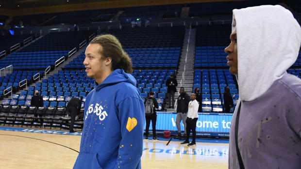 Mac Etienne walks on the court for UCLA before a game.